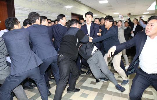 지난해 4월 26일 더불어민주당 의원과 보좌관들이 새벽 여야4당의 수사권조정법안을 제출하기 위해 자유한국당 당직자들이 점거하는 국회 의안과 진입을 시도하면서 몸싸움을 벌이는 모습.     연합뉴스